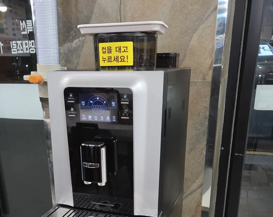매장 입구 옆 받침대에 놓인 전자동 원두커피 머신